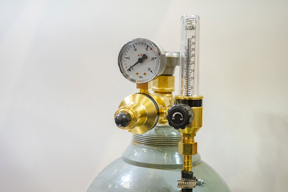 Gas tank fitted with pressure gauges representative of regulator repair work