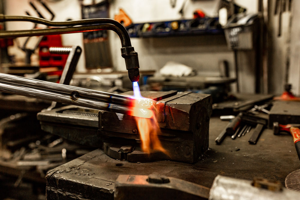 Technician welding metal using properly calibrated gas equipment